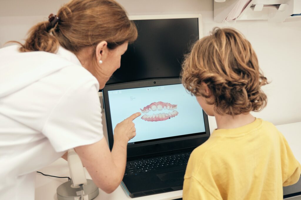 Dentist showing teeth scan to boy