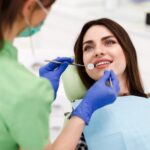 Beautiful young woman doing tooth examination in the dental office.